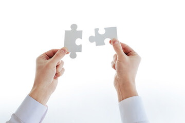 cropped image of a businessman looking at the puzzle pieces.