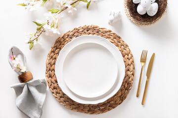 Easter table setting with blooming apple flowers on white table.