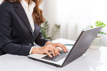 Woman's hand typing on laptop keyboard, businesswoman working in the office.