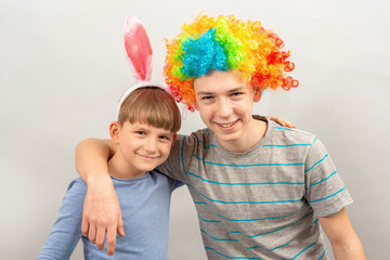 A child in Easter ears stands with boys in a clown wig.