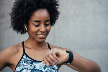Fitness woman checking time on smart watch.