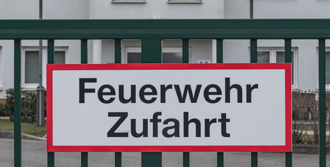 Ein Schild mit der Aufschrift Feuerwehrzufahrt an einem Zaun