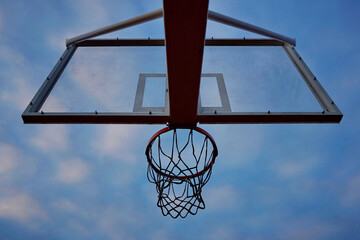 Basketball hoop with net on an outdoor court with sky and clouds  background