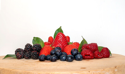 Berries on a wooden base. Blueberries, strawberries, raspberries and blackberries.
