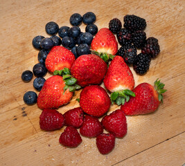 Berries on a wooden base. Blueberries, strawberries, raspberries and blackberries.