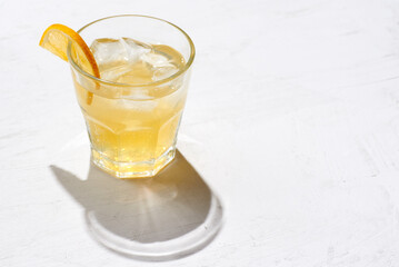 Minimalistic photo glass of alcoholic or non alcoholic kombucha with lemon slice  on a concrete background.