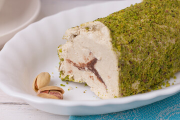 Eastern sweet chocolate halva with pistachios on a wooden table