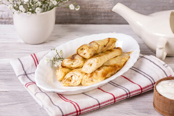 Rolled up thin pancakes stuffed with cottage cheese with raisins