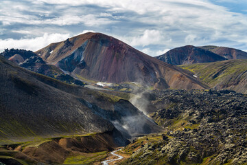 Coloured mountains landscape with river and cold lava stream in Landmannalaugar, Fjallabak Nature Reserve, Iceland, Europe