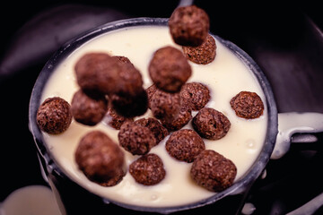 close-up round high speed chocolate cereal on yogurt with dark background