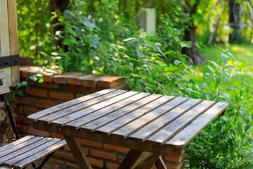 Selective focus of empty wooden table or plank with chair or bench on background for product display.