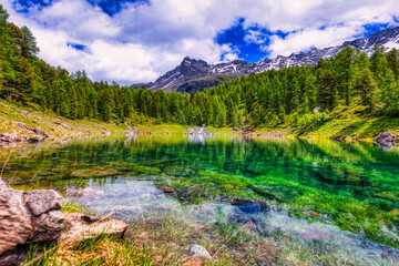 Amazing clear water in Scispadus Lake with the Swiss Alps in the background