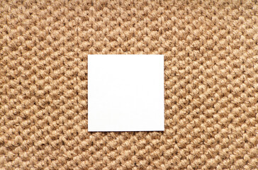 Empty mockup poster. Blank white square card on knitted jute rug. Minimal interior design. Modern style.