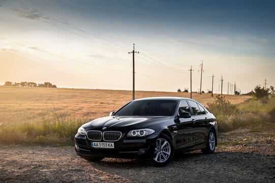 Kherson, Ukraine - June 2019. BMW 5-series F10 in a black color in the field. 