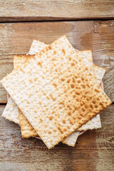 Matza sheets on top of each other lies on a wooden table.