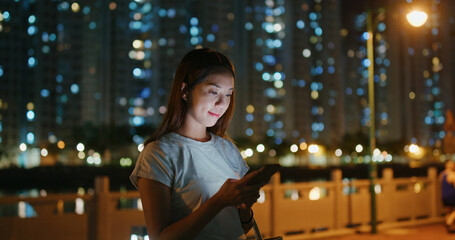 Woman use of smart phone in city at night
