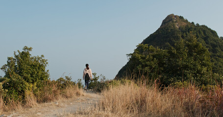 Fototapeta premium Woman go hiking to the top of the mountain