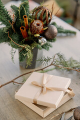 Christmas bouquet for table decoration from thuja, spruce branches in wooden box. Using of floral foam, cones, roses, balls. New Year celebration.
