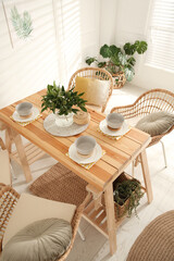Stylish wooden dining table and chairs in room. Interior design