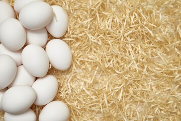White chicken eggs in on wood shavings. Easter. Shooting from above close up. Pattern. Place for...
