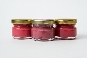 Three jars of fruit jam on white background.