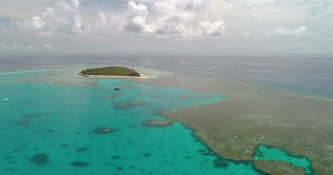 Forward tracking aerial view over the blue water and corals of the great Barrier Reef with the coral atoll called Lady Musgrave island, Queensland, Australia