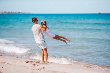 Little girl and happy dad having fun during beach vacation