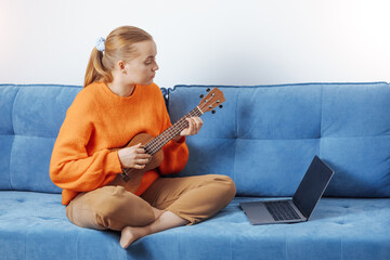 A girl plays the ukulele