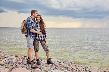 Couple in love kissing on nature travel hiking in Hawaii mountains. Young hikers people happy together.