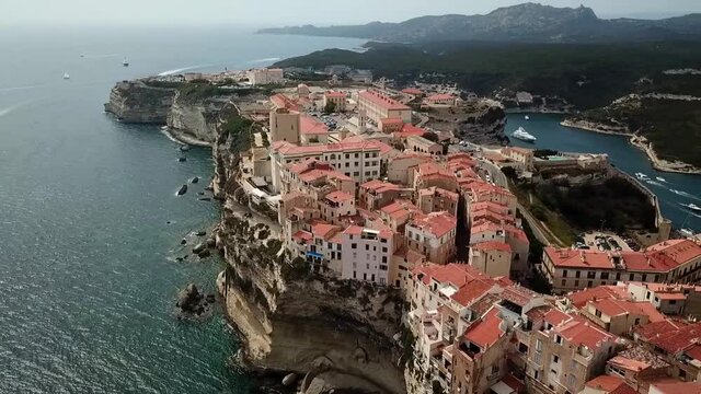 Drone pans over the Citadelle and the city of Bonifacio on the island of Corsica built on cliffs, France.