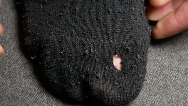 Black Socks with the hole. Torn sock. Unemployment people, poverty, economic crisis