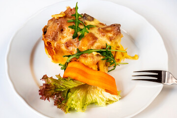 Baked pasta with salad, carrot and rucola leaf.