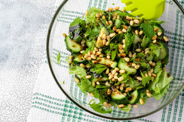 Healthy food concept: green salad with cucumbers, mint, pine nuts and balsamic. Selective focus....