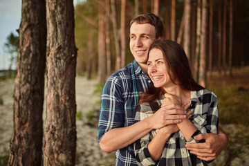 young couple smiling at each other during a romantic date in the forest