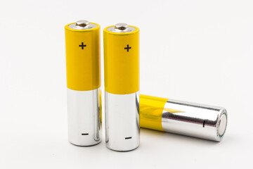 Photo of gray-yellow alkaline AA batteries on white background. Recycling of rechargeable NiMH batteries. The most popular size of accumulators. Copy space.