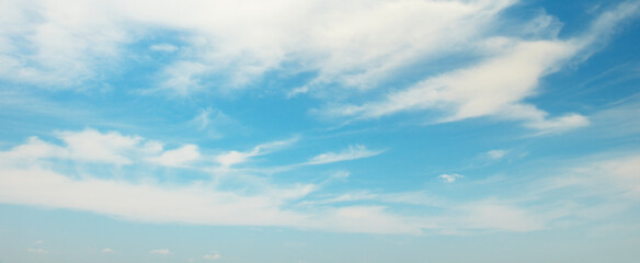 Naklejka na ściany i meble Fluffy clouds on bright blue sky