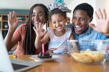Family celebrating birthday on a video call.