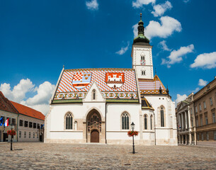 The bright and beautiful St. Mark Church with the roof coats of arms of Zagreb and of Triune Kingdom standing in the center of St. Mark square in old city. Zagreb, Croatia