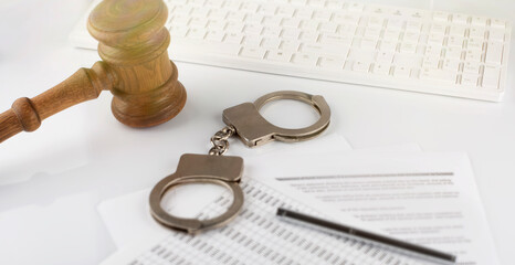 Keyboard , gavel and handcuffs on the documents. Top view.
