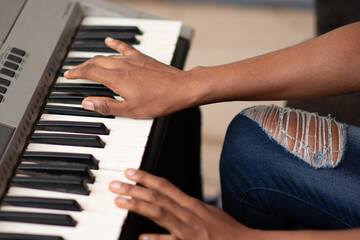 Fototapeta na wymiar hands only of a young african woman playing a piano