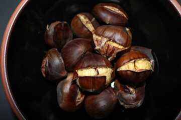 Baked chestnuts on black background.
Roasted chestnuts
