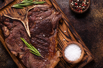 Grilled beef steak with spices on a wooden board