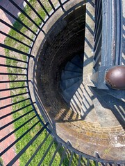 Looking Down At Stone Spiral Staircase With Brick Walls and Metal Railing