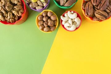 Nuts for children in colorful cups. Walnuts, pistachio, hazelnuts, brazil nuts, cashews, pecans....