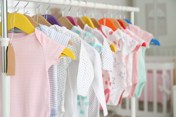 Baby clothes hanging on rack in store. Shopping concept