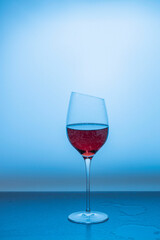 Close up view of red wine in glass isolated on blue background. 