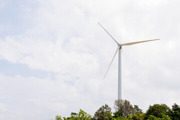 Wind turbine in the wind with white clouds.