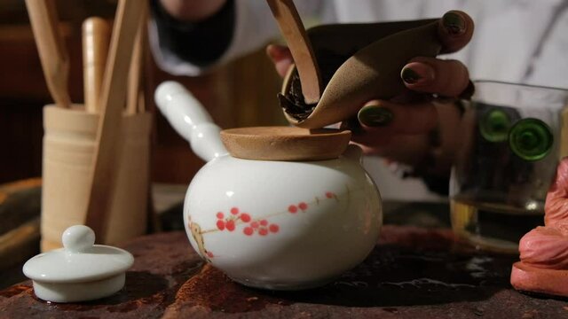 The tea master pours tea from the chahe into the teapot. Slow motion close-up, macro shot. Traditional Chinese tea drinking ceremony. Chinese Japanese tea, Puer Shu Gong Ting Xiao Tocha Oolong Zhang