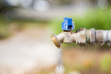 Exterior dripping water faucet or tap in yard