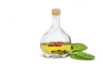 Bottle of oil with spices on white isolated background